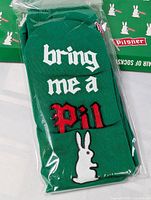 Packaged green Pilsner novelty socks showing design and unopened state