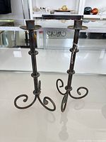 Pair of wrought-iron candle holders standing upright