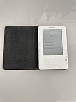 Front view of white Amazon Kindle e-reader inside black folio cover showing empty battery screen