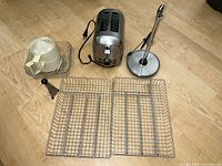Group shot of toaster, two wire baskets, glass dish, juicer, grater, towel holder