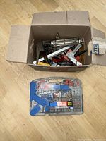 Cardboard box with assorted tools and separate Tora drill bit case