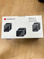 Retail box top showing AudioSource branding and VS 2.1 Home Theater Speaker System label