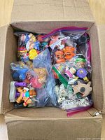 Open box showing multiple zipper bags of colourful plastic toys