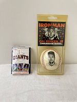 Both items side by side: sealed Giants playing cards and Cal Ripken Jr baseball package