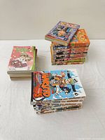 Three stacks of manga showing Naruto, One Piece and Karin volumes