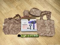 All items laid out: boxed Remington hair dryer, two leopard totes, leopard pouches, green umbrella