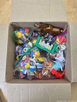 Box with multiple zip bags of Little People figures, horse, castle wall accessory visible
