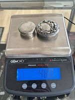Two silver lids on scale reading 48.0 grams