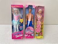 Front view of three boxed dolls