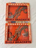 Two boxed sets of Hager Ornamental Shelf Brackets front view