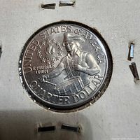 Close-up of 1776-1976 quarter in flip showing drummer boy reverse and legends