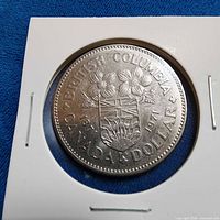 Close-up of coin in holder showing British Columbia arms and dates 1871-1971