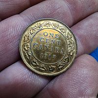 Reverse of 1917 Canada one cent coin in hand
