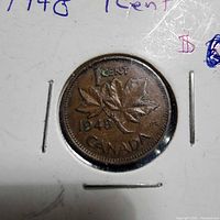 Reverse side of 1948 Canadian 1 cent coin showing maple leaves, denomination and year