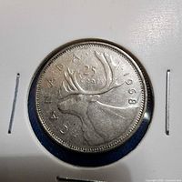 Front view of 1968 Canadian quarter in cardboard holder