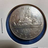 Full view of 1975 Canadian dollar coin in holder, reverse side
