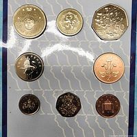 Full view of eight-coin set in display card, showing reverse designs