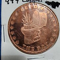 Obverse of copper round showing toilet and cannabis leaves, text GET OFF THE POT