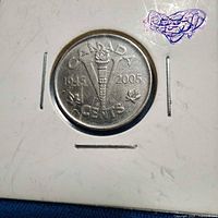 Reverse of 2005 Canadian V-torch five-cent coin in holder