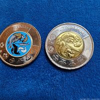 Both 2024 Inuit Nunangat toonies, colorized and non-colorized side by side