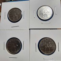 Four 1973 Canada 25-cent coins in holders