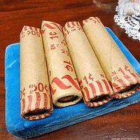 Four paper coin rolls resting on blue pad