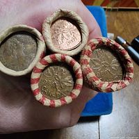 Four coin rolls end view showing dated cents 1964, 1965, 1968, 1969
