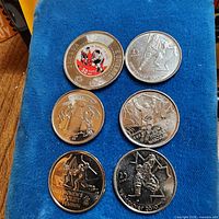 All six coins laid out on blue cloth