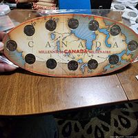 Front of oval holder showing all 12 coins on Canada map background