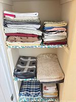 Multiple stacks of folded linens on shelves