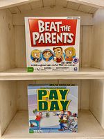 Beat the Parents and Pay Day board games on shelf