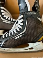 Close-up of right skate showing Bauer Supreme branding, laces, quarter package material