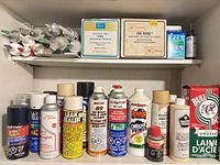 Overall view of two shelves showing aerosol cans, grout boxes, caulking tubes and small chemical containers