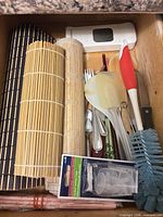 Drawer view showing bamboo mats, utensils, brushes, outlet caps package