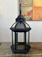 Front view of black hexagonal outdoor lantern with clear glass