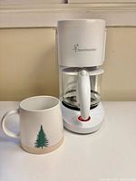 Coffee maker and ceramic mug front view