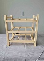 Front view of wooden bottle rack showing three tiers