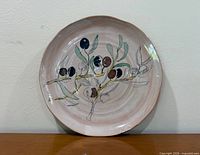 Front view of round platter showing entire olive branch design