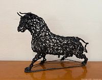 Left-side view of twisted wire bull sculpture on base