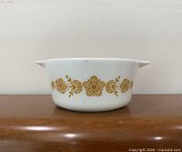 Side view showing Butterfly Gold pattern band on white glass casserole