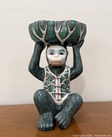 Front view of monkey figurine holding bowl