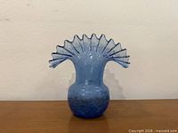 Front view of blue crackle glass vase showing ruffled rim and crackle texture