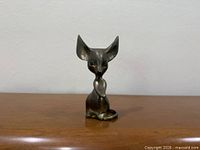 Front view of brass mouse figurine showing overall form and patina