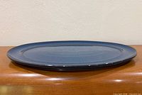 Side profile of blue speckled oval ceramic serving dish
