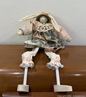 Full view of rabbit doll seated on surface showing overall design and wooden feet