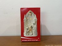 Front of product box showing porcelain nativity accent light image
