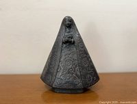Front view of black clay Virgin of Solitude figurine showing incised floral designs