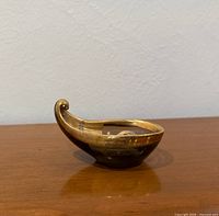 Profile view showing curled handle shape and amethyst glass with gold banding