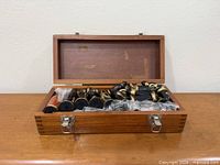 Wooden box open showing packed chess pieces in plastic sleeves