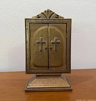 Closed metal prayer display on pedestal base
